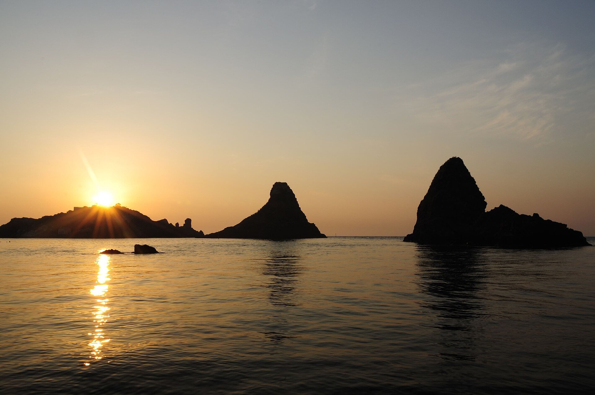 Faraglioni dei Ciclopi sea stacks at dawn in Aci Trezza Sicily
