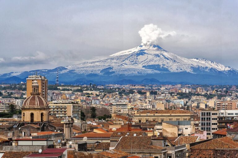 Aerial view of Catania city with Mount Etna rising behind it