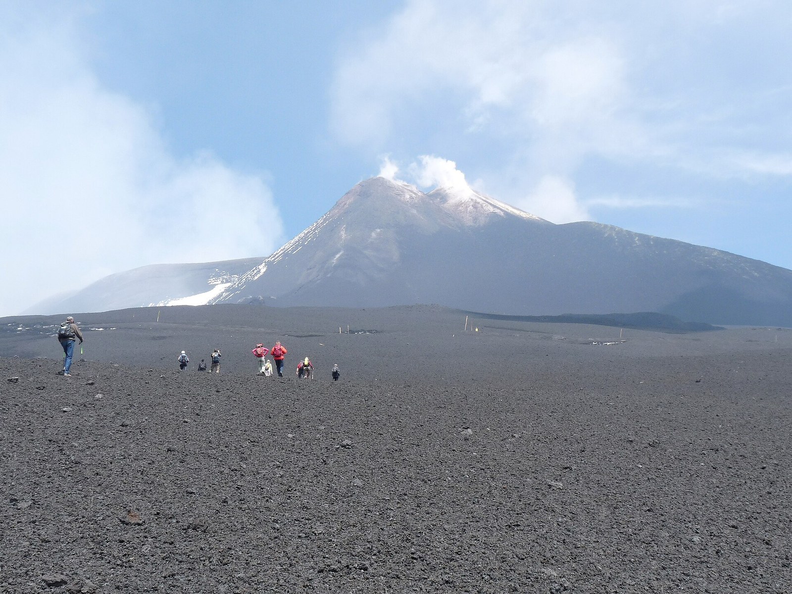 Group of hikers walking on a Mount Etna volcanic trail