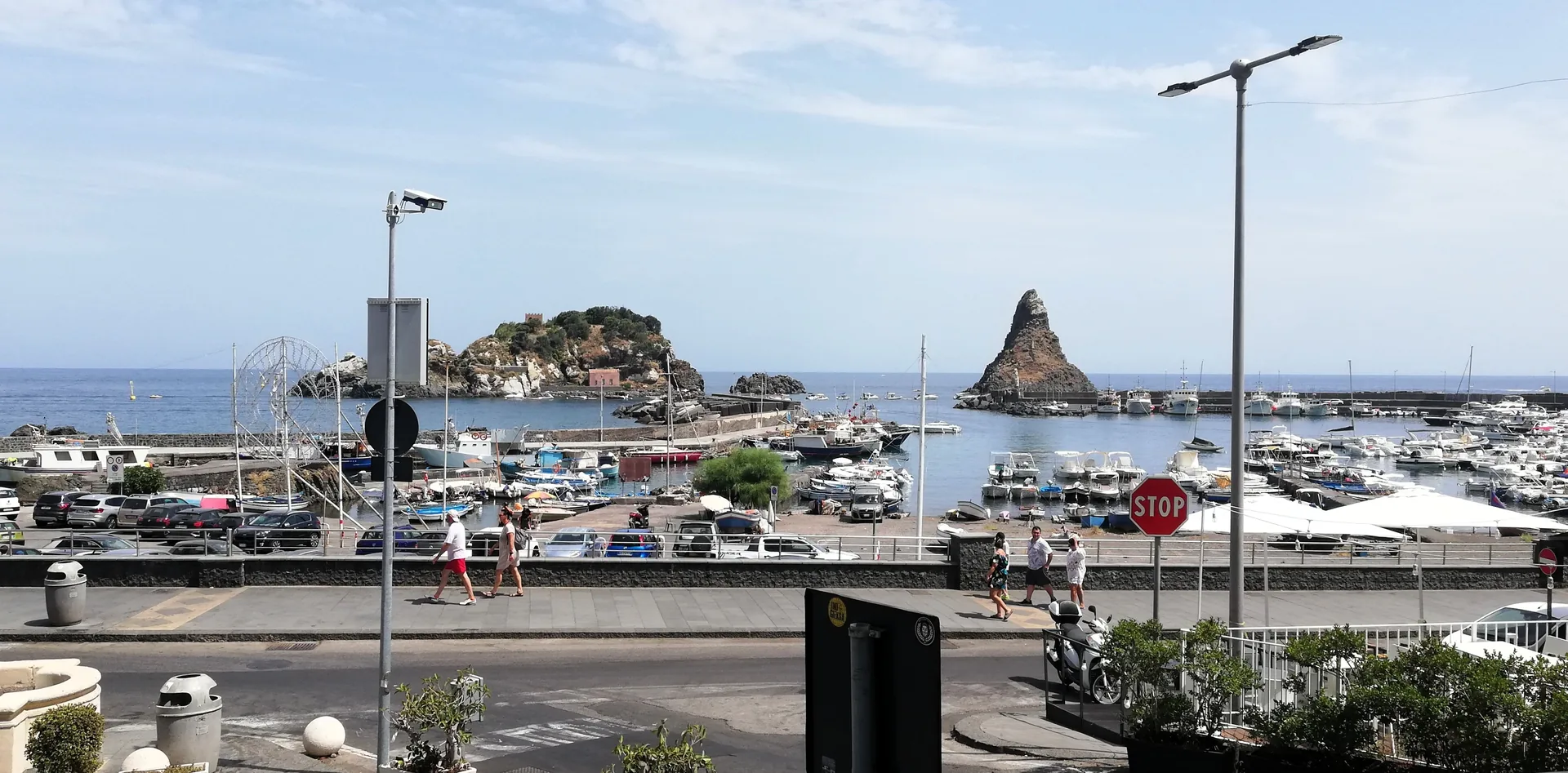 Porticciolo di Aci Trezza con barche di pescatori e gozzi tradizionali ormeggiati, vista verso i Faraglioni