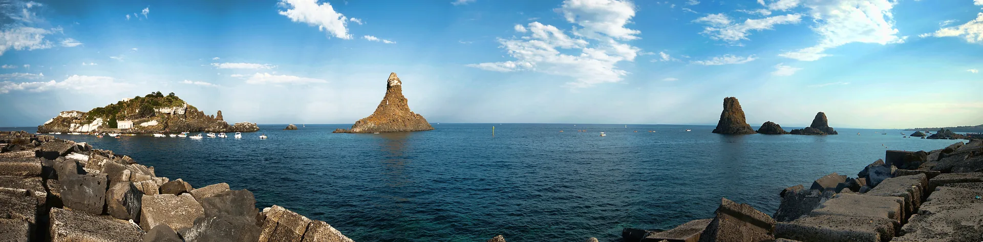 Vista panoramica di Aci Trezza sulla Riviera dei Ciclopi, costa ionica della Sicilia con i Faraglioni e il borgo marinaro