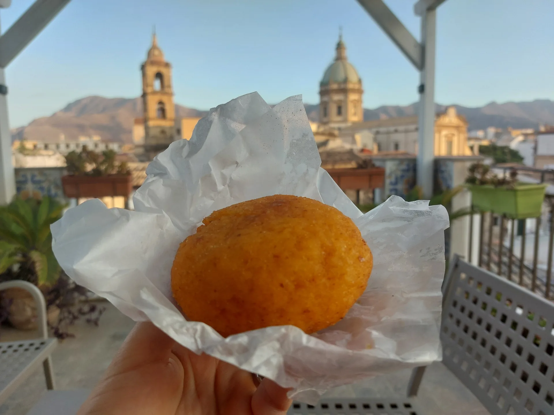 Arancina palermitana di forma tonda, contrasto con arancino catanese