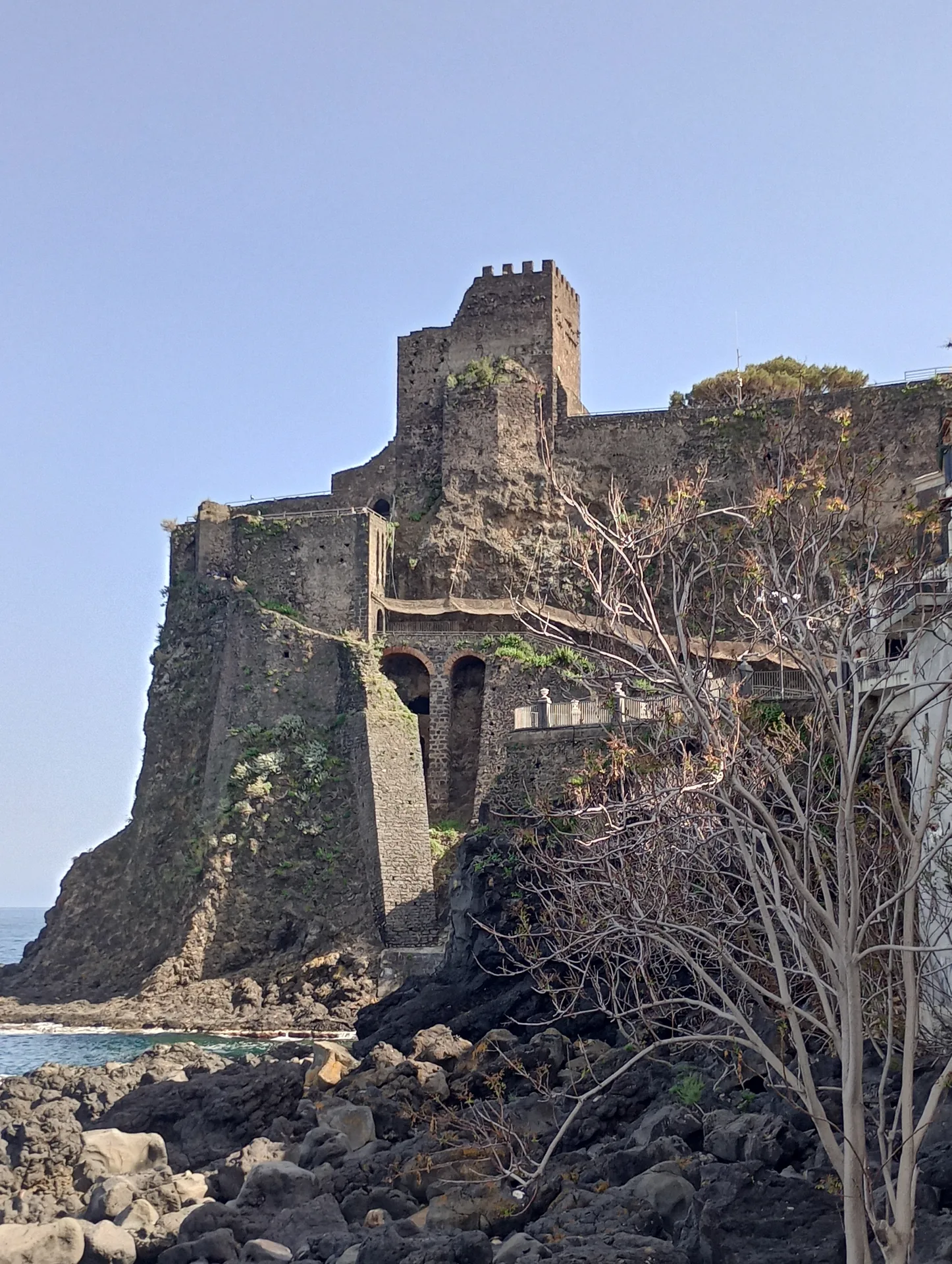 Castello Normanno di Aci Castello facciata in pietra lavica nera con merli e finestre medievali costruito nell'XI secolo