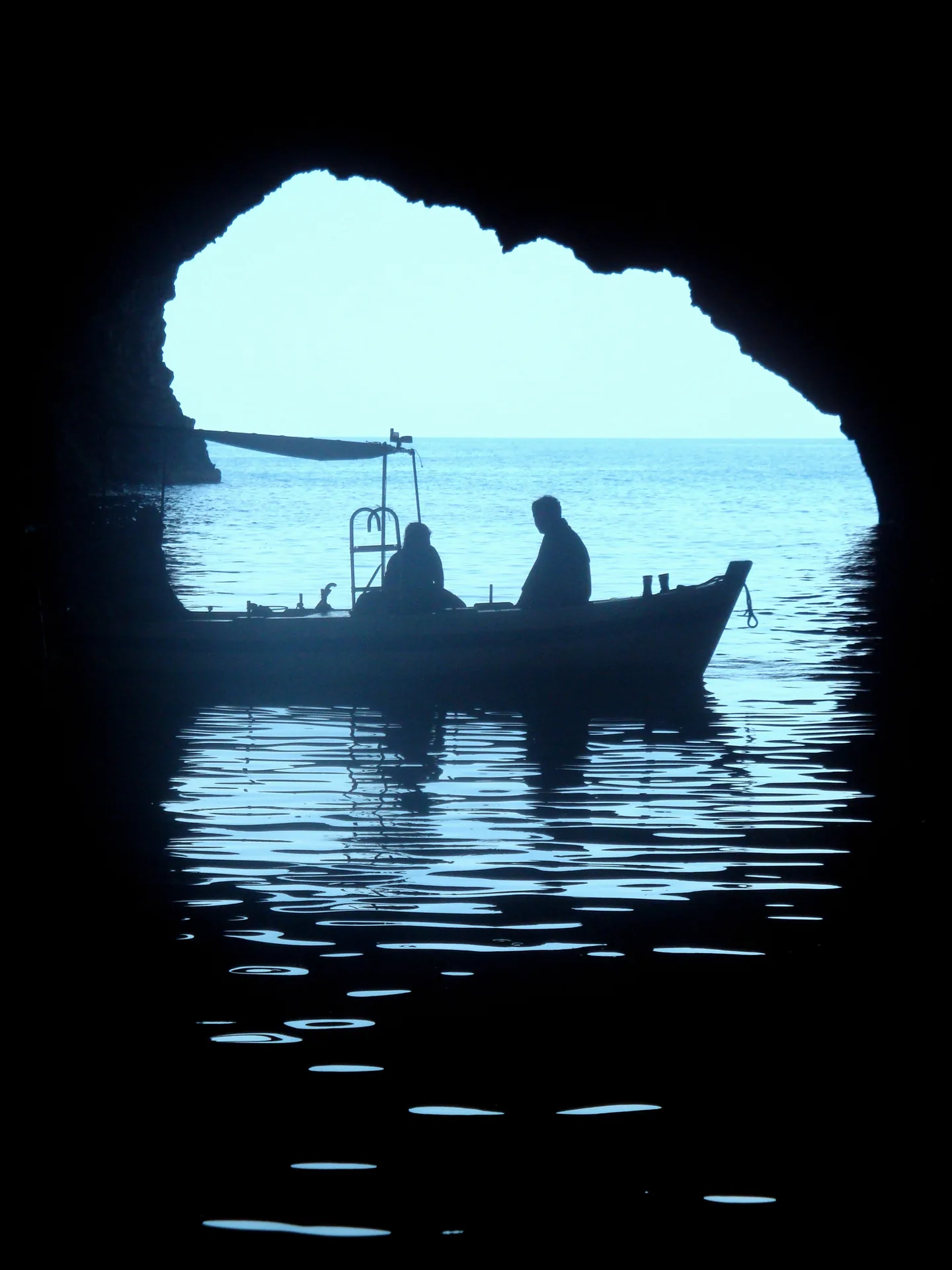 Kayakers exploring the Grotta del Bue Marino sea cave on Filicudi island in the Aeolian Islands, Sicily