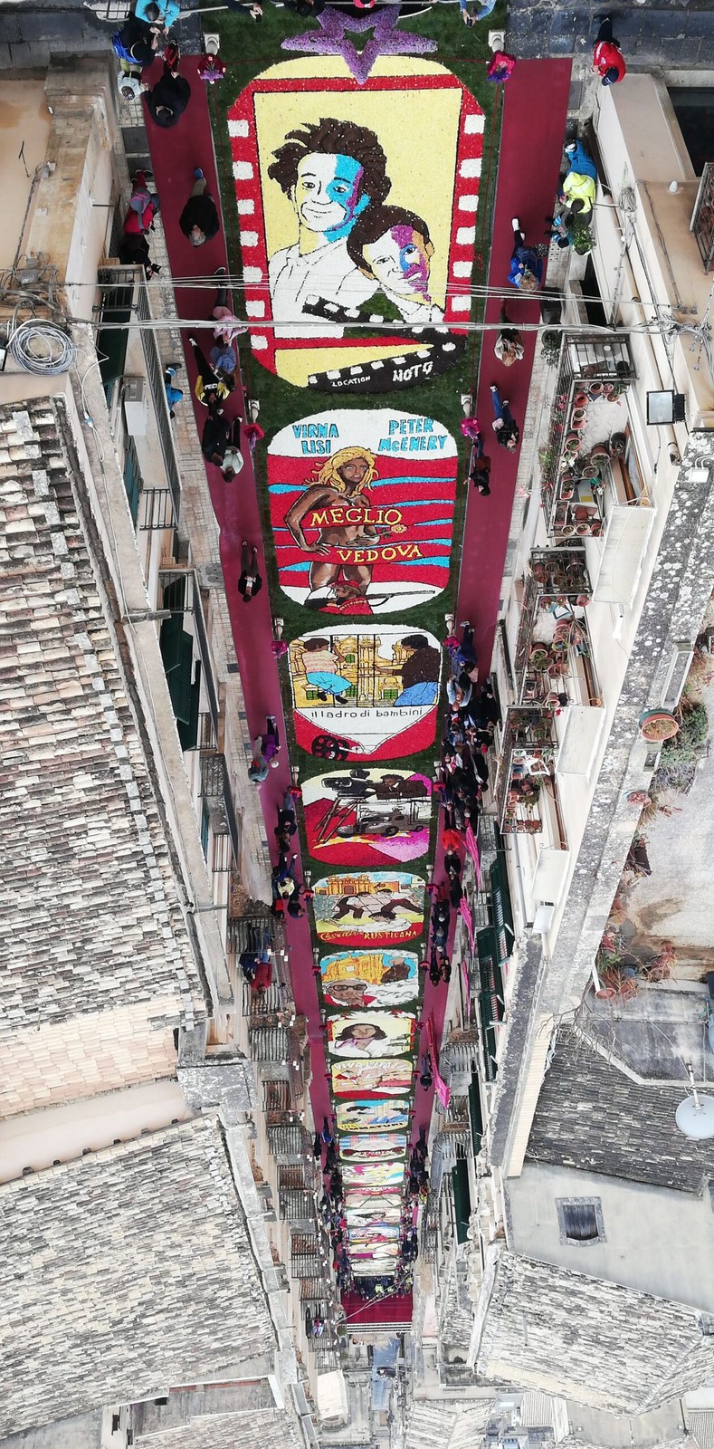 Aerial view of the Infiorata di Noto flower carpet on Via Corrado Nicolaci, Sicily — third Sunday of May, 700 m² of petal mosaics in 16 panels