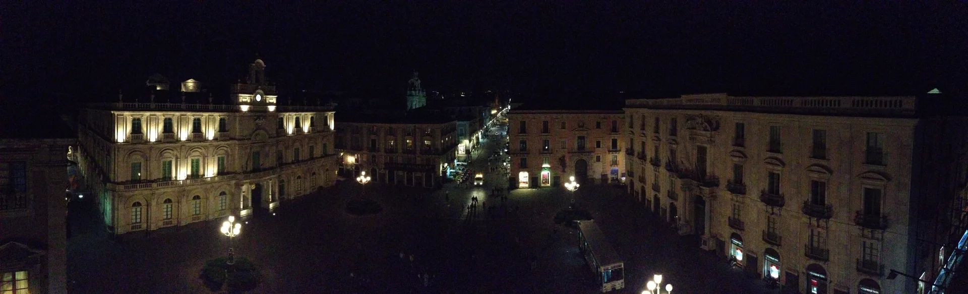 Piazza Università di Catania illuminata di notte, locali del centro storico aperti per aperitivo e cocktail