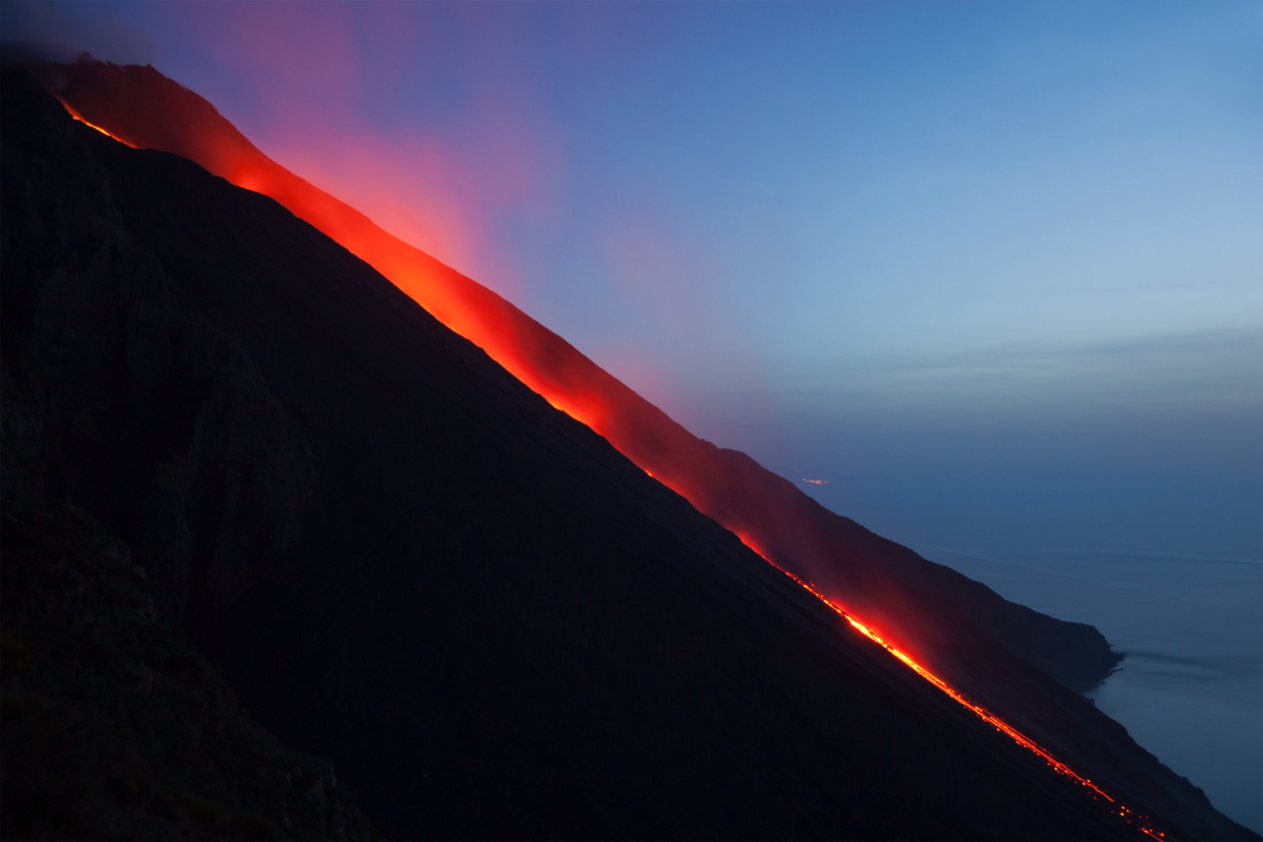 Stromboli volcano sciara del fuoco lava flow at night — Aeolian Islands volcanic activity visible from the sea after sunset in September