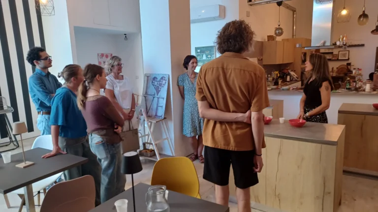Sicilian cooking class students rolling cannoli shells hands-on with chef instructor