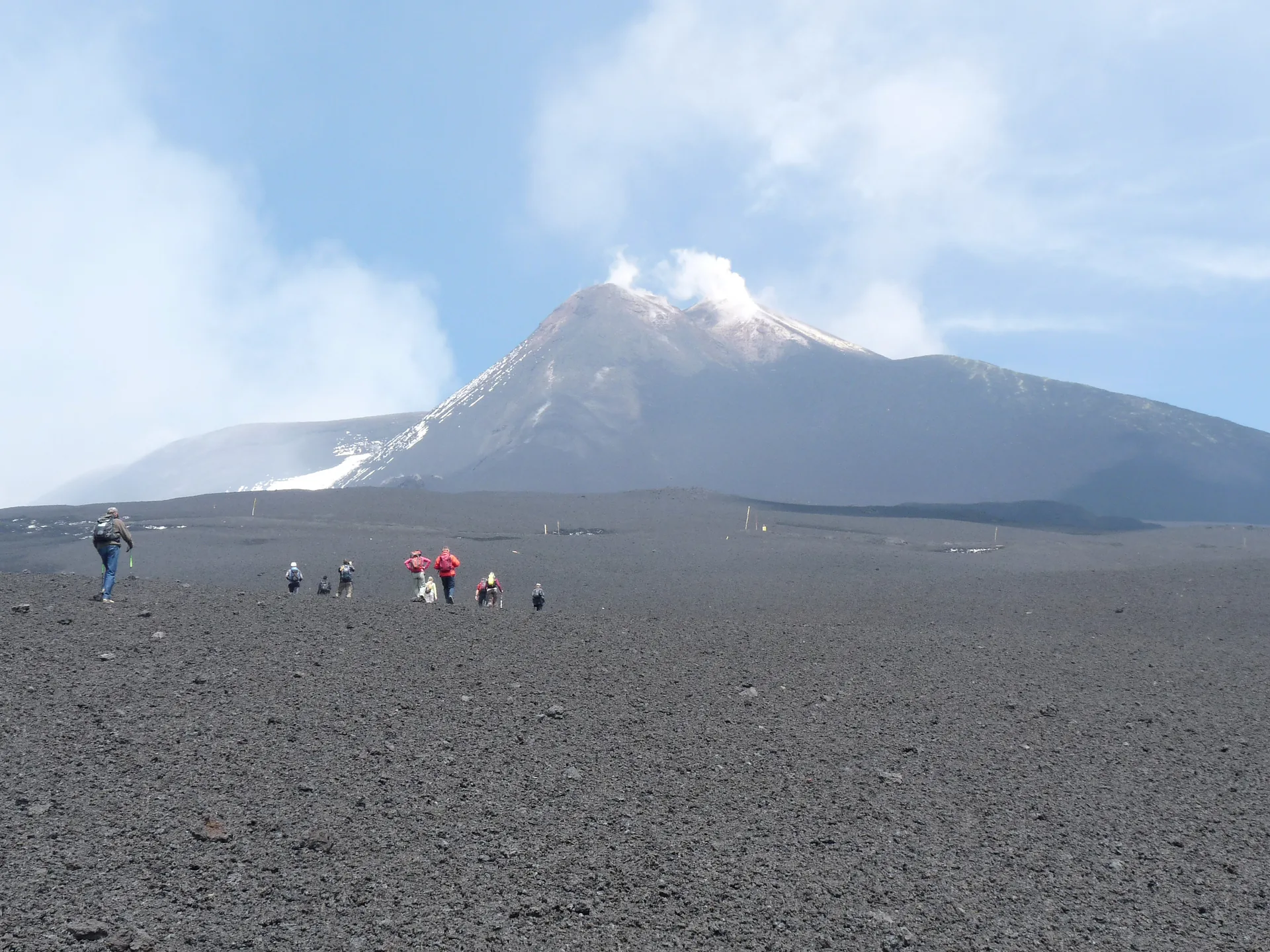 Group of hikers wearing layers on a Mount Etna volcanic trail